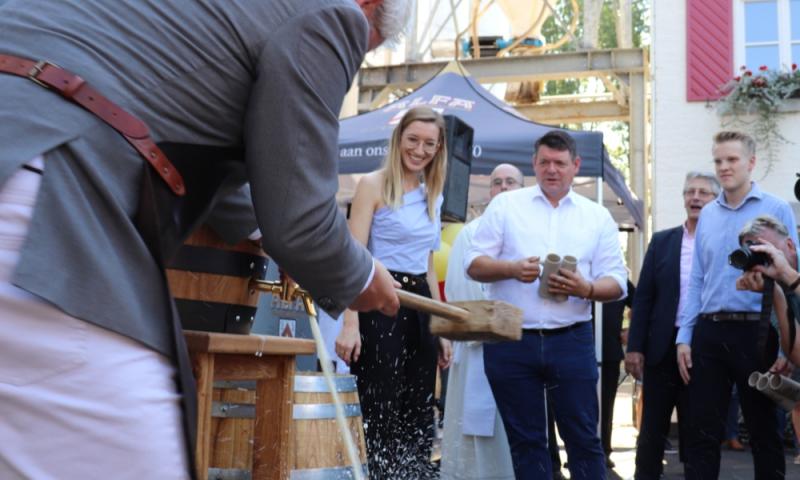 Burgemeester heeft fust Alfa Bier aangeslagen met de familie Meens op de achtergrond